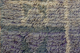 Shaggy wool pile of vintage Moroccan carpet showing abrashed violet and ivory tones.