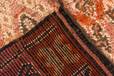 Vintage Moroccan carpet's hand-knotted foundation, rust and ivory stripes, dark selvage, and high pile.