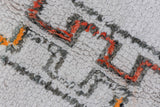 High-low pile texture of the vintage Moroccan carpet in ivory, charcoal, and terra cotta.