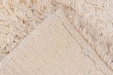Plush ivory pile texture revealing the tightly woven foundation of a Tulu rug.