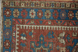 Hand-knotted vintage Karaja rug detail, geometric pawn pattern in brick red, indigo, beige.