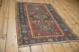 Intricate geometric indigo border and brick red field of the vintage Karaja rug.