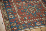 Vintage Karaja rug close-up: side selvage, brick red and indigo geometric patterns, visible wear.