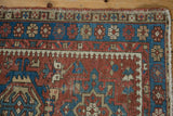Corner detail of vintage Karaja rug, brick red and indigo blue geometric pawn motifs, visible wear, reduced outer border.