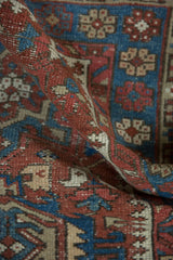 Vintage Karaja rug pile detail, showing brick red and indigo geometric motifs with faint foundation.
