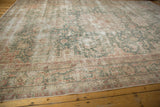 Faded raspberry, ocean green, and ivory floral vinery on a distressed vintage Sparta carpet.