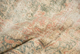 Distressed pile of the Vintage Sparta rug, showing faded ivory, blush, and muted green patterns.