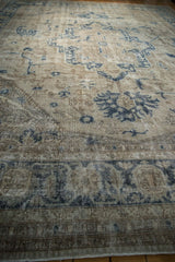 Distressed vintage Sparta rug texture with visible foundation, dusty navy, and antique ivory patterns.