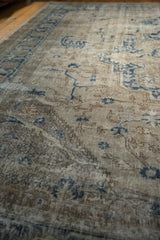 Distressed pile texture of a vintage Sparta carpet, with beige and dusty navy motifs.