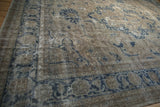 Distressed vintage Sparta rug showing time-softened dusty navy and ivory geometric floral motifs.