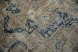 Textured pile of distressed Sparta rug, showing faded dusty navy geometric patterns and wear.