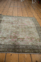 Distressed Karabagh rug's even wear revealing pink, silver, and bronze floral motifs.