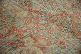 Distressed Mahal carpet with muted terracotta, ivory, and blue floral vines and abrashes.