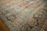 Distressed Mahal carpet corner: muted terra cotta and silver floral vines, worn texture.