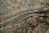 Worn pile detail of a distressed Mahal carpet, dusty brick and muted blue floral patterns.
