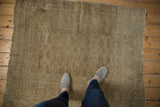 Worn texture of a vintage distressed Turkmen rug, showing faded beige elephant footprint guls.