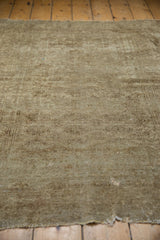 Distressed Turkmen rug showing worn beige pile, faint gul motifs, and tattered edge.