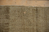 Tattered edge and visible holes on distressed vintage Turkmen rug, showing light foundation.