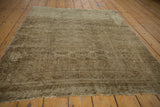 Tattered end of a distressed vintage Turkmen rug with worn gul patterns.