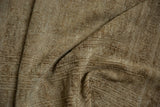 Distressed beige Turkmen rug's worn texture showing faint foundation.