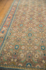 Distressed Bijar runner's allover herati pattern in soft beige, blue, and terracotta with visible wear.