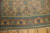 Distressed vintage Bijar runner corner: terracotta arabesque border, worn beige Herati field, and fringe.