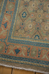 Vintage distressed Bijar runner corner: arabesque border, herati motif, beige, blue, terracotta.