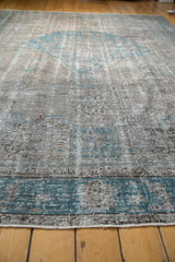 Close view of a distressed Oushak showing mostly even wear with silver and turquoise hues.