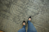 Distressed Oushak carpet with muted ivory and silver large scale design motifs.