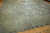 Distressed vintage Oushak carpet corner, showcasing muted tones and even pile wear.