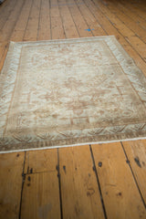 Lower section of distressed Sivas rug showing ivory field and reciprocating wave border.