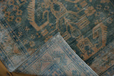 Detail of the distressed green and gold geometric pile, with visible foundation and side selvage.
