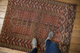 A standing perspective on the short pile and geometric patterns of an antique Turkmen rug.