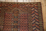 Corner detail of a Turkmen Hatchli rug showing serrated geometric borders in red and navy.