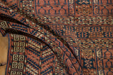 The intricate geometric weave and short pile of an antique Turkmen rug shown in a soft fold.