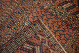 Detail of the woven side cord selvage on an antique Turkmen rug with red and navy geometric designs.