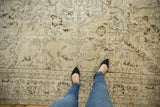 Distressed vintage Oushak carpet featuring worn floral design, faint foundation, ivory, brown, time-softened silver tones.