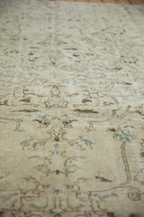Distressed Oushak rug with time-softened ivory pile and subtle asymmetric floral vinery.