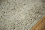 Distressed floral vinery in ivory, silver, and brown on a vintage Oushak rug's worn pile.