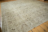Vintage distressed Oushak carpet displaying an ivory field, chocolate brown floral patterns, and subtle foundation wear.