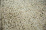 Distressed Oushak rug surface with faded floral motifs and visible ivory foundation.