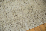 Distressed Oushak rug's worn ivory and brown floral patterns, showing texture and fringe.
