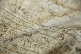 Faint ivory, brown, and silver floral vinery on the distressed Oushak rug pile.