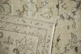 Distressed vintage Oushak rug showing worn pile, faded motifs on ivory, visible foundation, and hand-knotted back.