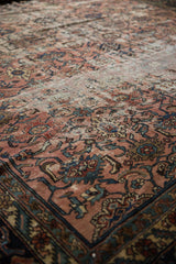 Distressed vintage Bibikabad carpet, close-up of muted raspberry field with worn Harshang-Herati florals.
