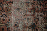 Distressed Bibikabad rug detail, revealing worn pile, foundation, and faded raspberry, navy, ivory motifs.