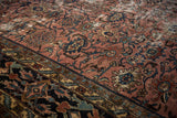 Worn Bibikabad rug detail: raspberry field, navy Herati-Harshang motifs, intricate palmette border.