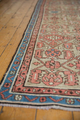 Distressed Hamadan runner's indigo border, faded terracotta Herati patterns, and worn pile texture.