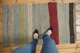 Hand woven Turkish Kilim rug with abrashed stripes in powder blue, dusty gold, purple, and green.