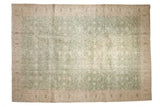 Vintage distressed Turkish Sparta carpet with faded green floral motif, ivory border.